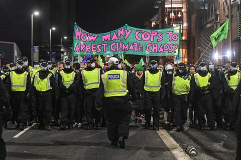 Glāzgova, Skotija 3. novembris policisti pavada iznīcības sacelšanās protestu pie Cop26 samita, jo tiek rādīts reklāmkarogs, kurā lasāms, cik policistu arestēs klimata haosu 2021. gada 3. novembrī Glāzgovā, Apvienotajā Karalistē, kad pasaules līderi tiekas, lai apspriestu klimata pārmaiņas Cop26 samitā, daudzas klimata rīcības grupas ir izgājušas ielās, lai protestētu pret reāls progress, kas valdībām jāpanāk, lai samazinātu oglekļa emisijas, attīrītu okeānus, samazinātu fosilā kurināmā izmantošanu un citus jautājumus, kas saistīti ar globālo apkuri. Foto: Peter Summersgtty attēlus