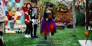 bērni spēlē apiņu spēli Helovīna ballītē