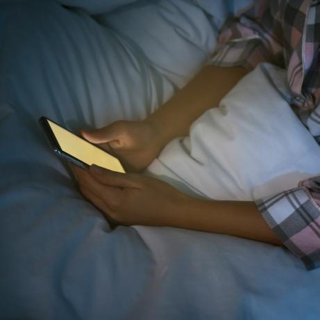 sieviete, kas naktī gultā lieto viedtālruni, tuvplāna nomofobija un miega traucējumu problēma