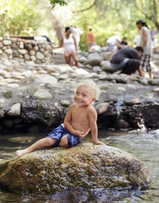 zēns uz klints pie ezera