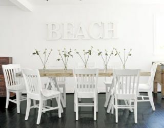 neformāla ēdamistaba ar saliekamiem krēsliem un pludmali ar baltiem burtiem uz sienas