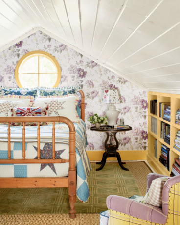 burvīga lauku guļamistaba ar koka gultu un gaiši violetu chintz tapetēm
