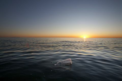 Plastmasas pudele, kas peld uz okeāna