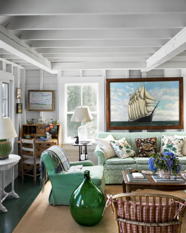 savākta Maine dzīvojamā istaba ar zaļu dīvānu un milzīgu vintage kuģa gleznu pie sienas